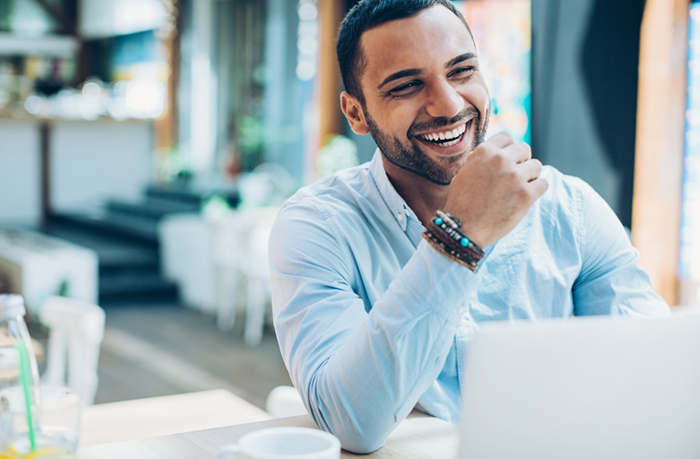 man sitting at desk and working on laptop